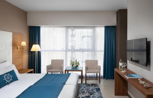 a hotel room with a bed and a table with chairs at Medi Terre Boutique Hotel - By Saida Hotels in Netanya