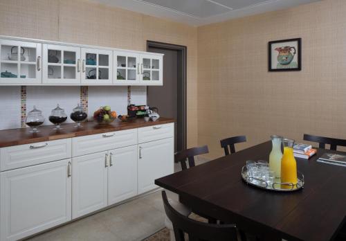 a kitchen with a table and white cabinets at Medi Terre Boutique Hotel - By Saida Hotels in Netanya