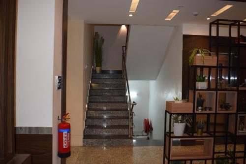 a spiral staircase in a building with a fire extinguisher at Hotel New Centro in Gulbarga