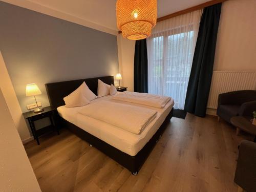 a bedroom with a bed and a large window at Hotel Berghof in Berg im Drautal