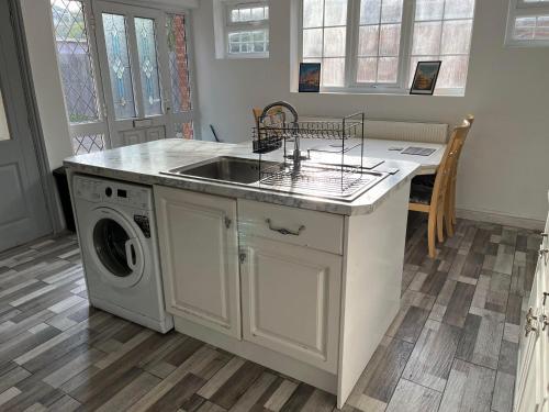 a kitchen with a sink and a washing machine at Willow House in Birmingham