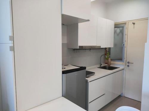 a kitchen with white cabinets and a sink at MyHome S1 At Seri Kembangan With A View in Seri Kembangan