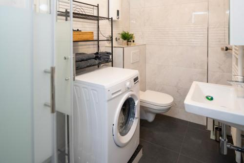 eine weiße Waschmaschine im Bad mit WC in der Unterkunft Travelers Dream Heart of Mannheim in Mannheim