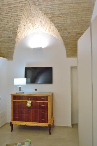 フェッランディーナにあるLorleo Suite Casa Vacanzeのリビングルーム(テレビ、木製ドレッサー付)