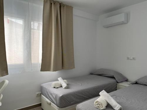 a bedroom with two beds with towels on them at Gran apartamento diseño in Alicante