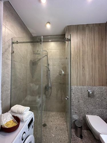 a bathroom with a glass shower with a toilet at Аль-Фараби-Ходжанова. Вид на горы. ЖК Оркен in Almaty