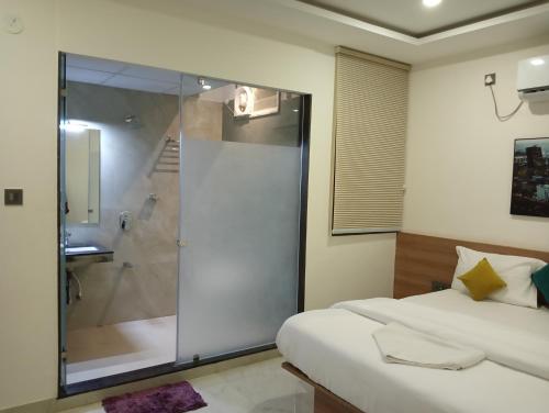 a bedroom with a glass shower and a bed at Hotel New Centro in Gulbarga