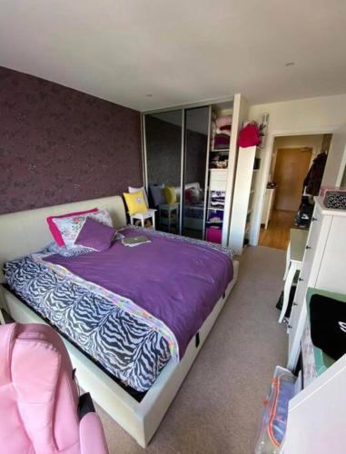 ロンドンにある1 bedroom apartmentのベッドルーム(紫の毛布付きのベッド1台付)