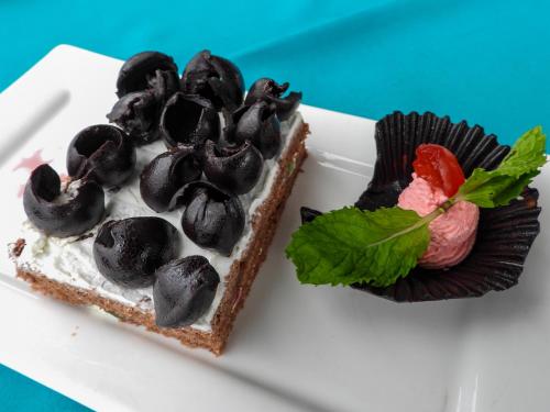 a piece of cake on a white plate with a dessert at Maru Maru Hotel in Zanzibar City
