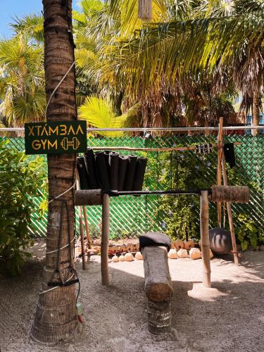 a tree with a sign on it next to a tree at Xtambaa Cabins & Spa Only Adults in El Cuyo