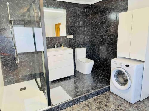 La salle de bains est pourvue d'un lave-linge et d'un lavabo. dans l'établissement Playa Bonita Apartment, à Puerto de Sagunto
