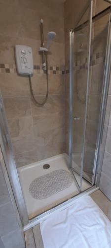 a shower with a glass shower stall with a shower at River side in Dingle
