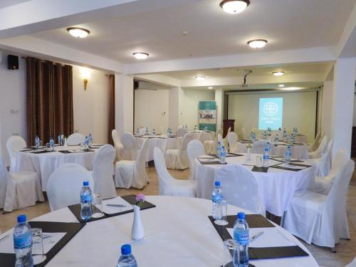 a conference room with white tables and chairs with water bottles at Maru Maru Hotel in Zanzibar City