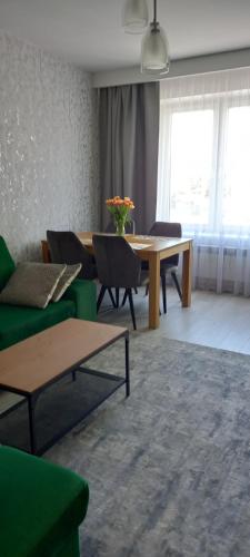 a living room with a green couch and a table at Apartament Grunwaldzka in Przemyśl