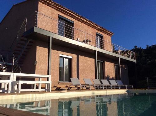 une maison avec une piscine à côté d'un bâtiment dans l'établissement Magnifique villa vue mer dans le golfe de St-Tropez, à Roquebrune-sur Argens