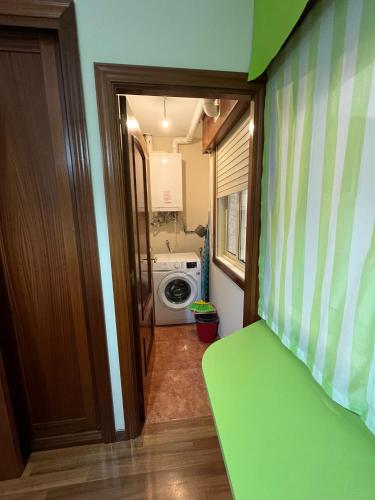 a bathroom with a laundry room with a washing machine at Apartamento Marichu in Melide
