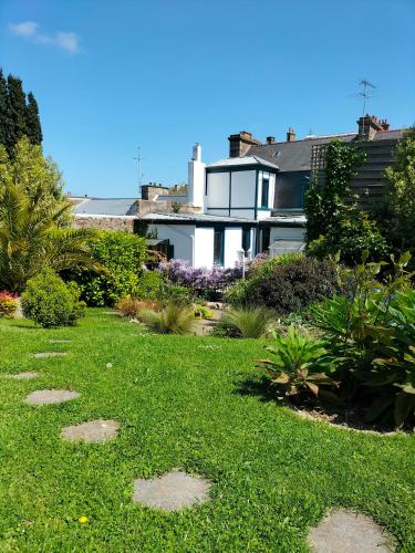a garden with rocks in the grass in front of a house at Le Jardin Secret & Spa - Chambre d'Hôtes in Saint-Brieuc
