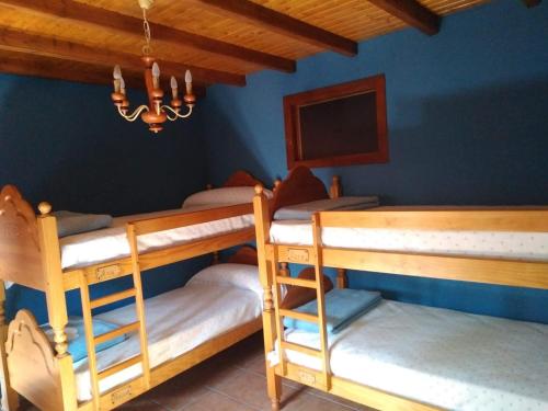 two bunk beds in a room with blue walls at Casa vacacional o trisquel in Pontevedra