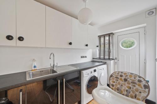 a kitchen with a sink and a washing machine at 5 Star Lux Coastal Gem - Indoor Heated Pool - Pets in Filey