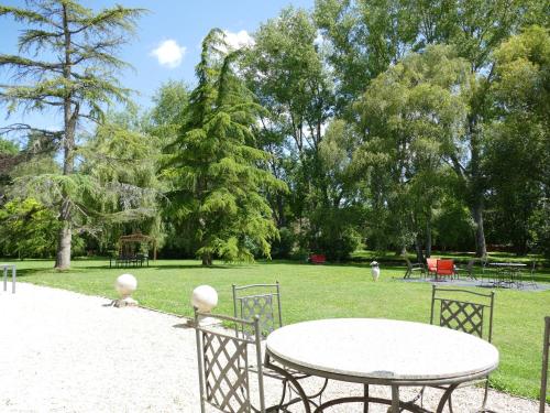 a table and chairs in a park with trees at La Feuillaie in Saint-Ay