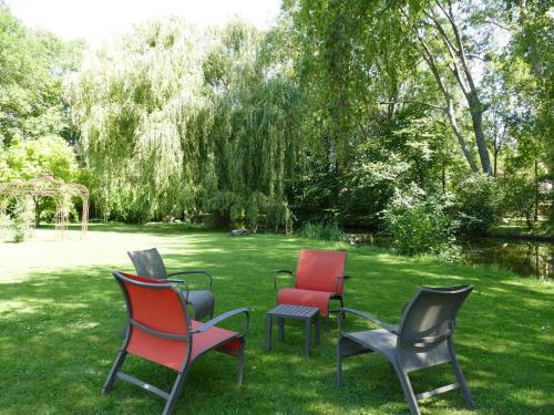 four chairs sitting in the grass in a yard at La Feuillaie in Saint-Ay