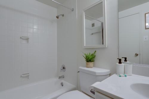 a white bathroom with a toilet and a sink at Modern & Luxury Condo at Crystal City in Arlington