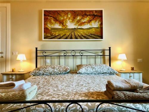 a bedroom with a bed and a painting on the wall at Sangi Chianti Vacations in Poggibonsi