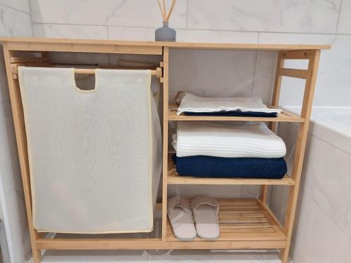 a wooden shelf with towels and shoes in a bathroom at Sweet place in Saint-Denis