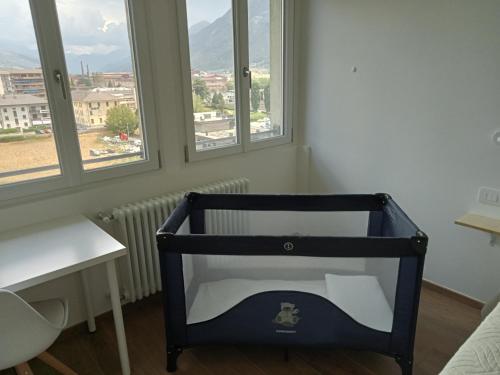 a black chair in a room with windows at Settimo Cielo Apartment Aosta CIR 0199 in Aosta