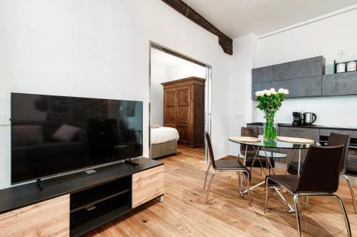 a living room with a large television and a table with chairs at Suite Lo Storico - The House Of Travelers in Como