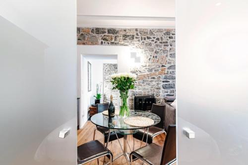 a dining room with a glass table and chairs at Suite Lo Storico - The House Of Travelers in Como