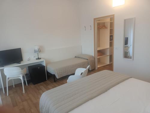 a bedroom with a bed and a desk with a computer at Hotel Splendid in Caorle
