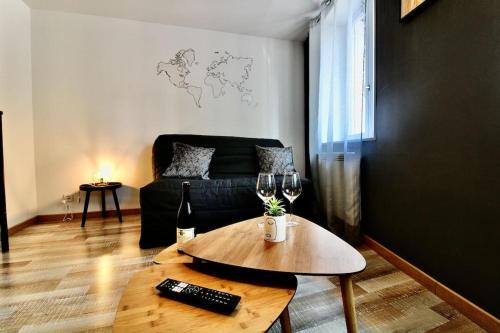 - un salon avec un canapé et une table avec des verres à vin dans l'établissement Studio Cocooning proche Gare, à Rouen