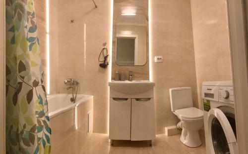 y baño con lavabo, aseo y espejo. en 2-х кімн квартира в новобудові, en Ternopilʼ