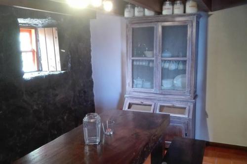 a wooden table in a room with a cabinet at Casas da Figueira in São Roque do Pico