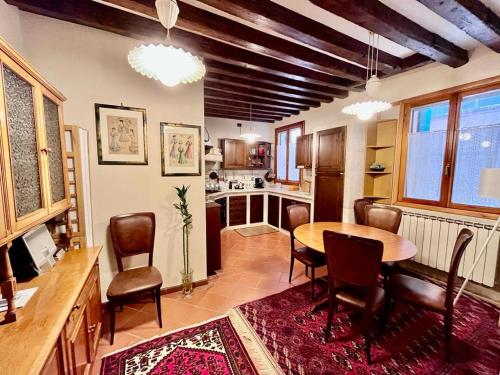 een keuken met een tafel en stoelen in een kamer bij Rifugio alle Vele in Venetië