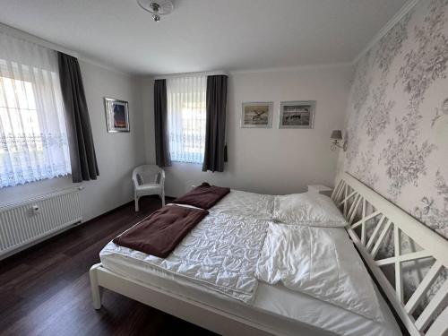 a bedroom with a white bed and a staircase at Ferienwohnung Lobbe 2 - 100qm in Lobbe