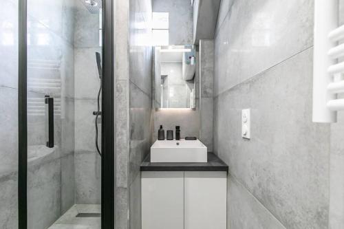 a white bathroom with a sink and a mirror at MBA Splendide Appart - Montreuil 6 - Proches Vincennes in Montreuil