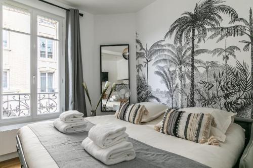 a bedroom with a large bed with towels on it at MBA Splendide Appart - Montreuil 6 - Proches Vincennes in Montreuil