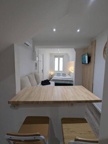 アジャンにあるRDC Studio Agen Hyper Centre - Clim - Voltaireのベッド、テーブル、椅子が備わる客室です。