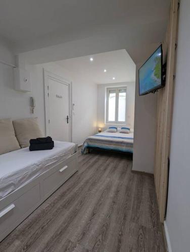 a bedroom with a bed and a flat screen tv at RDC Studio Agen Hyper Centre - Clim - Voltaire in Agen
