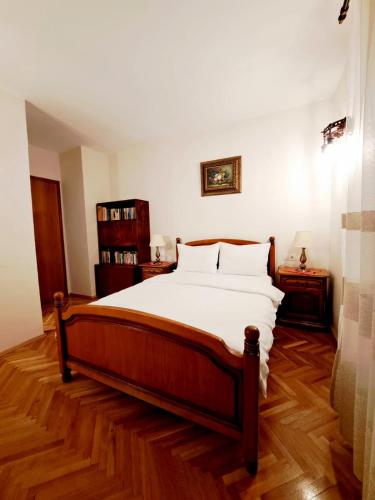 a bedroom with a large bed and a wooden floor at VILA COCA Sibiu in Sălişte