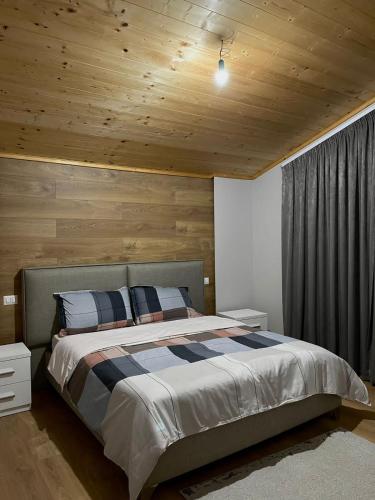 a bedroom with a large bed with a wooden ceiling at Albanian Traditions Legacy in Durrës