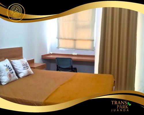 a bedroom with a bed and a desk and a window at Apartemen Transpark Juanda Bekasi by FYM ROOM in Padurenan