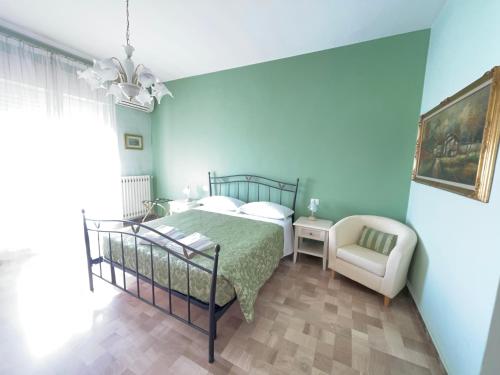 a blue bedroom with a bed and a chair at La Locomotiva in Chiaravalle