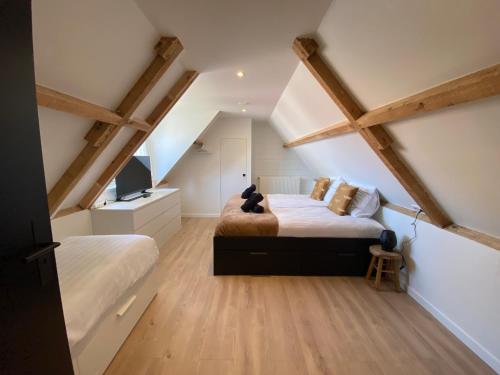 um quarto com 2 camas num sótão em The island life beach house 2 em De Koog