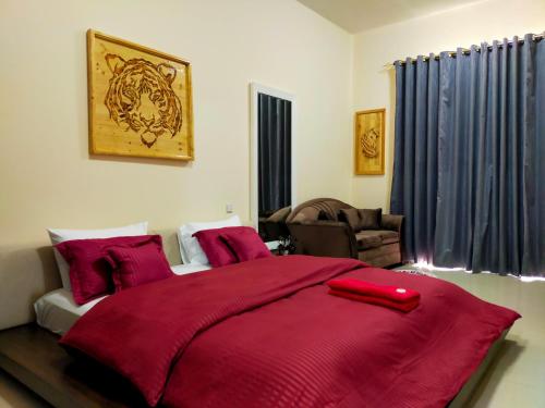 a bedroom with a large bed with a red blanket at Sea View Studio 5 Royal Breeze سي ويو ستوديو رويال بريز in Ras al Khaimah