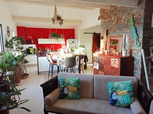 sala de estar con sofá y cocina en logement atypique avec jacuzzi et piscine, en Carnoules