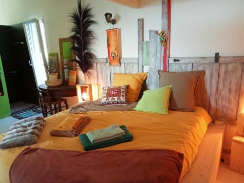 Una cama grande con algunas almohadas encima. en logement atypique avec jacuzzi et piscine, en Carnoules