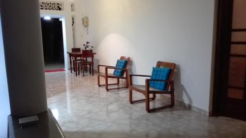 a room with three chairs and a table and a table at Crescent N Cocoon in Ambalangoda